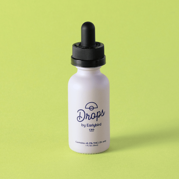 White bottle with black dropper labeled 'Drops by Earlybird' on a green background
